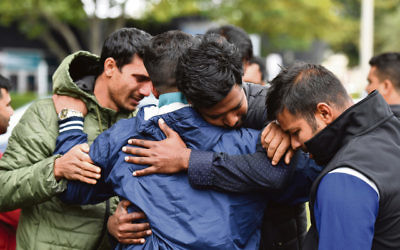 Friends of a missing man grieve outside a refuge centre in Christchurch last Sunday. Photo: AAP Image/Mick Tsikas