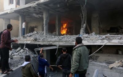 Palestinians walk through the wreckage of a building that was damaged by Israeli airstrikes in Rafah, in the southern Gaza Strip, May 5, 2019. (Abed Rahim Khatib/Flash90)
