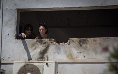Residents of southern Israel survey the damage to their home by a rocket fired from Gaza on May 4, 2019. (Hadas Parush/Flash90)