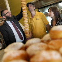 Chanukah 2010 in Sydney. Rabbi Mendel Kastel with part of a doughnut menorah.. Photo: Ingrid Shakenovsky