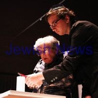 Yom Hashoah 2012. Robert Blackwood Hall, Monash University. Esther Werblub lighting a memorial candle with her grandson James Lesh. Photo: Peter Haskin