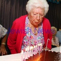10-2-12. 100 year old Genia Simon blowing out tthe candles on her birthday cake with the help of her son, Charles Simon. Photo: Peter Haskin