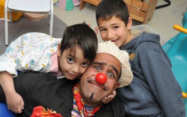 David "DuSH" Barashi, Hadassah Hospital’s head medical clown, with two young admirers.