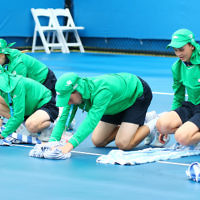 14-1-16. Australian Open Womens Qualifying round 1. Ball kids mop up the wet court after a rain delay. Photo: Peter Haskin