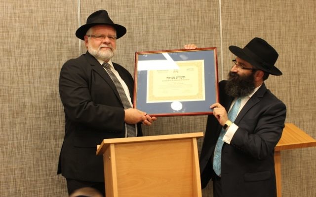 Shmuel Morris (left) is presented with his certificate of rabbinical ordination from Rabbi Motty Liberow of Hamerkaz Shelanu.