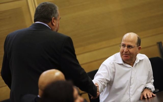 Moshe Ya'alon (right) shakes hands with Avigdor Lieberman at the Knesset in Jerusalem. Photo: JPost/Reuters.