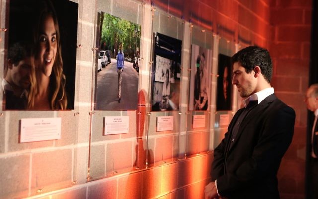 Cameron Graf examines photographs on display at the launch of the Humans of JCA exhibition. Photo: Giselle Haber