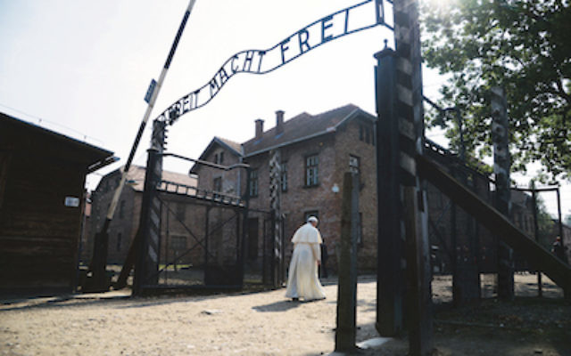 Pope Francis walks through the gate of the former Nazi German death camp of Auschwitz in Oswiecim, Poland, Friday, July 29, 2016.  Pope Francis paid a somber visit to the Nazi German death camp of Auschwitz-Birkenau Friday, becoming the third consecutive pontiff to make the pilgrimage to the place where Adolf Hitler's forces killed more than 1 million people, most of them Jews. (Filippo Monteforte/Pool Photo via AP)