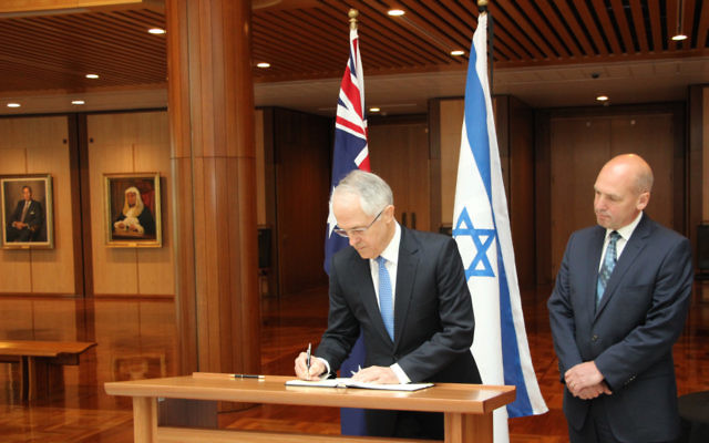 Prime Minister Malcolm Turnbull signs a condolence book in Canberra in honour of Shimon Peres. Pictured next to him is president of the Senate, Stephen Parry.