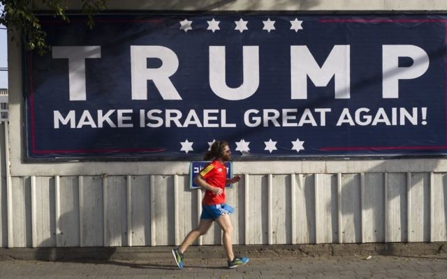 An Israeli jogger passes a pro-Trump placard in Tel Aviv. Photo: EPA/Jim Hollander