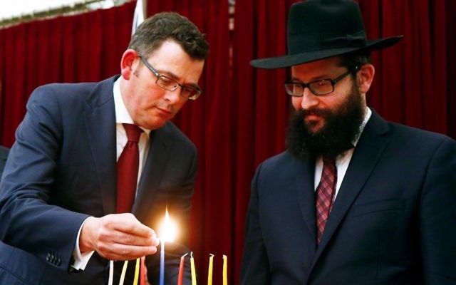 Victorian Premier Daniel Andrews lighting chanukiah candles with Rabbi Chaim Herzog. Photo: Peter Haskin