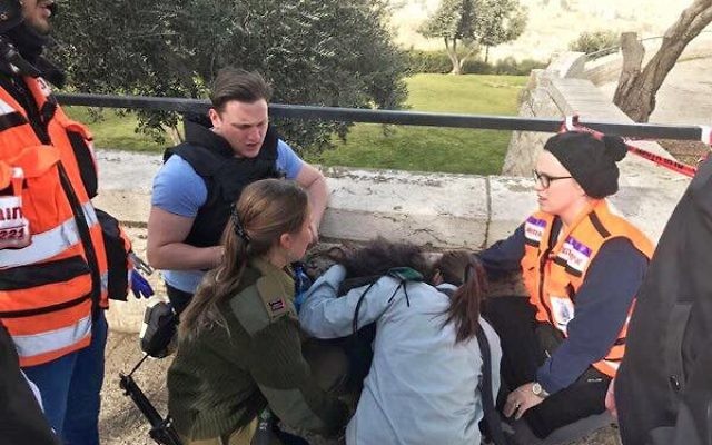 Dovi Meyer (back) helping to treat a victim of the January 8 terror attack in Jerusalem.
