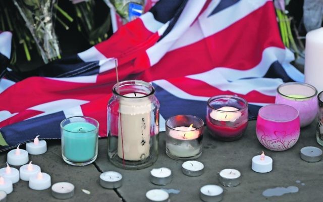 Flowers and candles are seen after a vigil in Albert Square in Manchester. Photo: AP Photo/Kirsty Wigglesworth