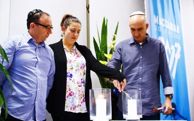 Tony Aarons, Rebecca Small and Daniel Zalcman lighting candles for the four Australians who lost their lives. Photo: Peter Haskin