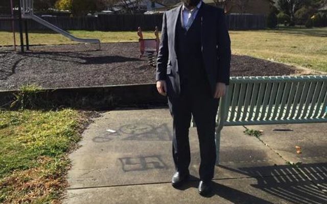 Rabbi Shmueli Feldman next to the swastika graffiti. Photo: Facebook.