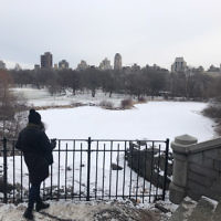 Racheli Shnider overlooking snow covered lake in Central Park, New York City