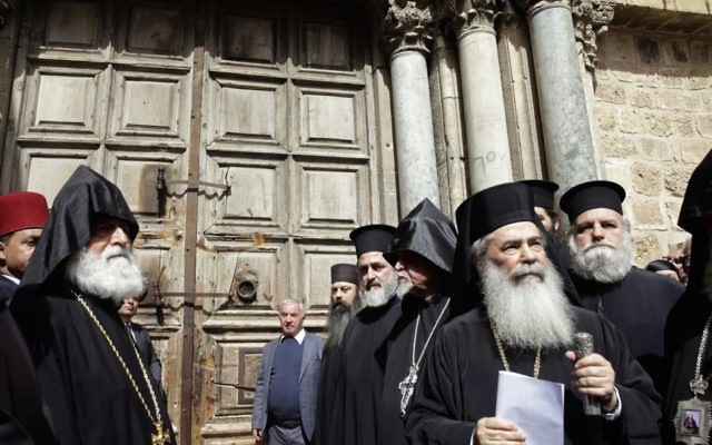 Theophilos III (second on right) stands outside the closed doors of the Church of the Holy Sepulchre during Sunday's protest. Photo: AP/Mahmoud Illean