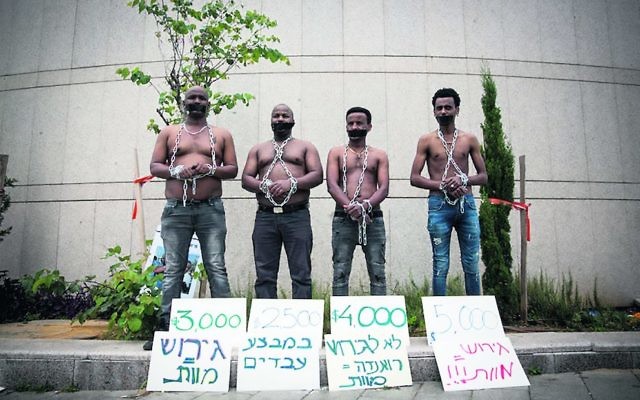 African asylum seekers set up a mock slave auction as part of a protest outside the Ministry of Defence on Tuesday. Photo: Miriam Alster/Flash90