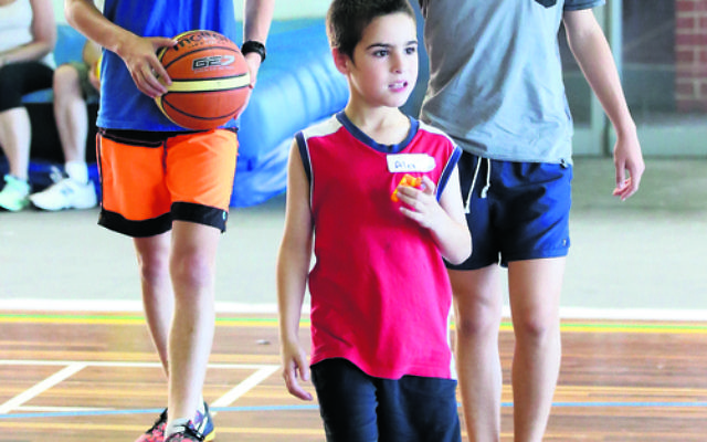 Alex joined other children from the Sydney Friendship Circle at a sports day with Maccabi junior basketball players in 2015. Photo: Noel Kessel