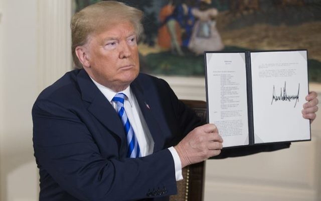 Donald Trump holds up the national security presidential memorandum on Iran that he signed this week. Photo: EPA/Michael Reynolds