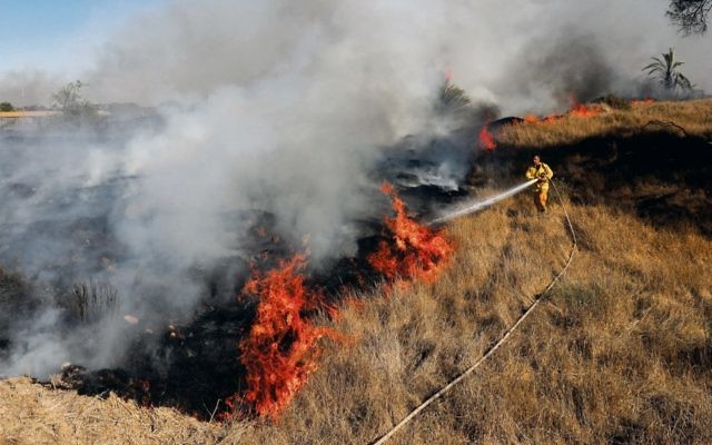Israeli firefighters try to douse a fire near Kibbutz Or Haner caused by kites from Gaza carrying Molotov cocktails. Photo: EPA/Abir Sultan