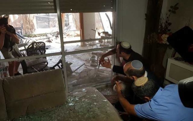 Sderot residents survey the damage to a house caused by a rocket from Gaza. Photo: Sderot Municipality