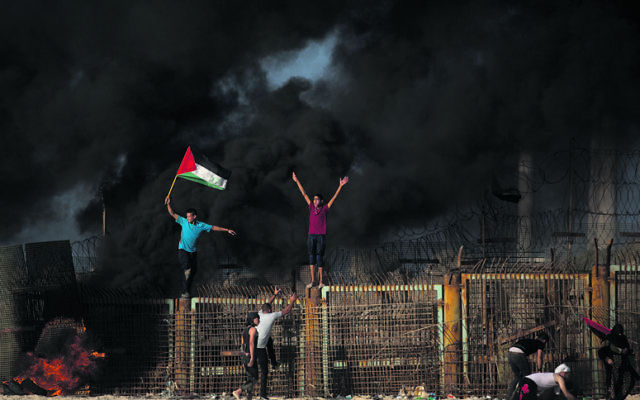 Palestinian protesters climbed over the border fence during a protest on the beach at the border with Israel near Beit Lahiya this week. Photo: AP Photo/Khalil Hamra