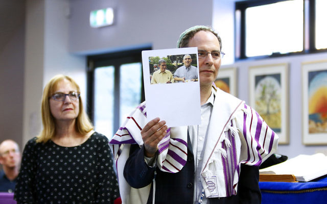 Rabbi Yonatan Sadoff holds up a photo of Cecil and David Rosenthal. Photo: Peter Haskin