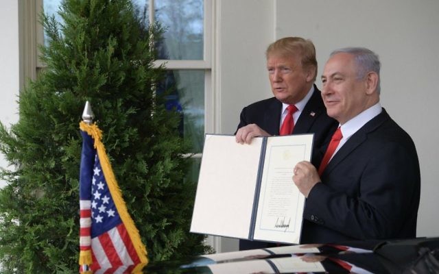 Prime Minister Benjamin Netanyahu and US President Donald Trump hold up the signed document acknowledging Israeli sovereignty over the Golan Heights. Photo: Twitter