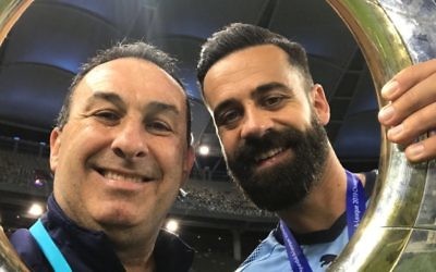 Michael Swibel (left) and retiring
Sydney FC captain Alex Brosque
hold the 2018/19 A-League trophy at
Optus Stadium in Perth last Sunday.