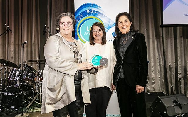 Claire Gil-Munoz (centre) and Isabelle Shapiro (right) accepting the award from Cathy Tobin at the National Suicide
Prevention Conference on July 23. Photo: Raimond Aide