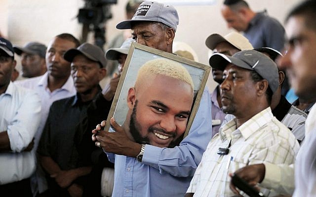 Family members and friends hold a picture of Solomon Teka during his funeral. Photo: EPA/Abir Sultan