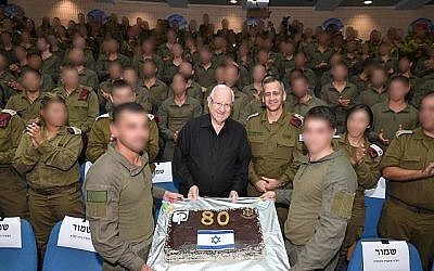 Members of the IDF Commando Brigade present President Reuven Rivlin with a cake at a surprise birthday party on Monday. (Mark Neiman/GPO)