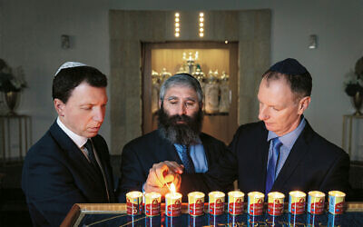 From left: Dvir Abramovich, Rabbi Motty Liberow and David Southwick light candles for the victims of the Tree of Life synagogue tragedy.