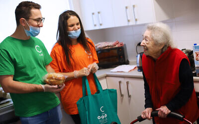 C Care volunteers Jeremy Sher and Taryn Abrahams deliver a C Care Shabbat pack to 98-year-old Rose
Sugarman. Photo: Peter Haskin