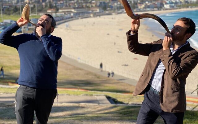 Rabbis Eli Schlanger and Yossi Friedman blowing shofars at Sydney’s Bondi
Beach in a previous year.