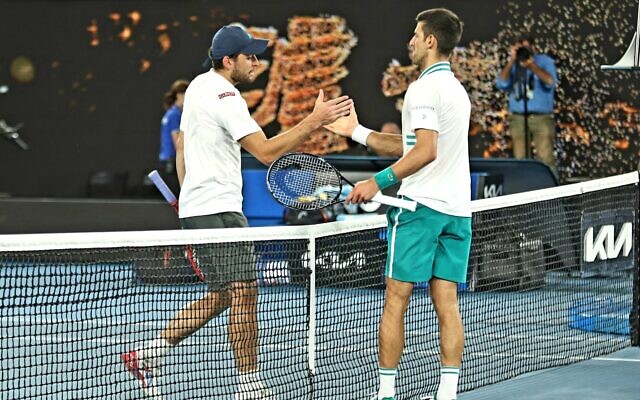 Aslan Karatsev shakes hands with Novak Djokovic at the Australian Open semi-final on Thursday night. Photo: Peter Haskin