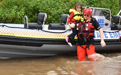SES assisting a family during their evacuation from a flooded property at
Upper Colo in north-western Sydney this week. Photo: AAP Image/Dean Lewins