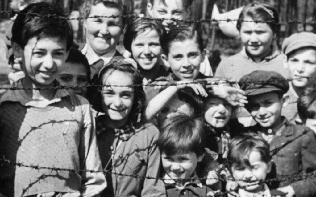 Children smiling through barbed wire at the Bergen-Belsen concentration camp a few weeks after liberation. Photo: Imperial War Museum