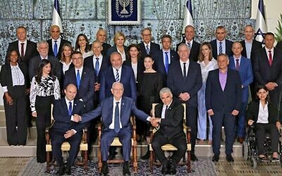 Outgoing Israeli President Reuvin Rivlin (C) is flanked by Prime Minister Naftali Bennett (L) and alternate Prime Minister and Foreign Minister Yair Lapid during a photo with the new coalition government, at the President's residence in Jerusalem, on June 14, 2021. - A motley alliance of Israeli parties on June 13 ended Benjamin Netanyahu's 12 straight years as prime minister, as parliament voted in a new government led by his former ally, right-wing Jewish nationalist Naftali Bennett. (Photo by EMMANUEL DUNAND / AFP)