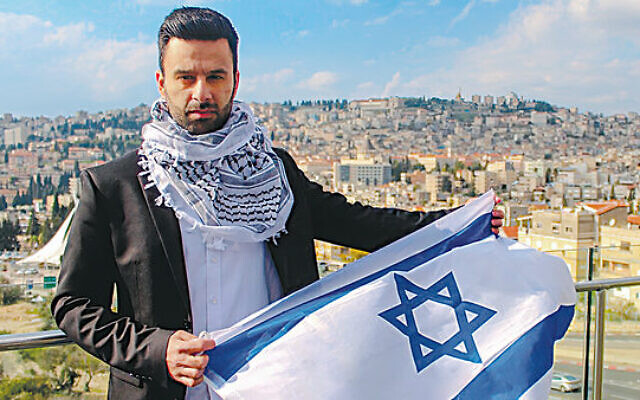 Yoseph Haddad proudly holding the Israeli flag in his home city of Nazareth.