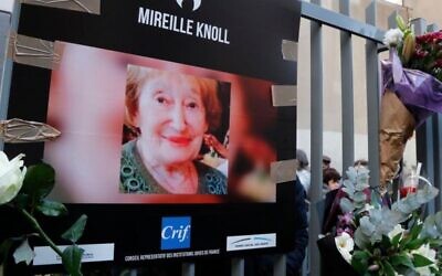 A photograph of murdered Holocaust survivor Mireille Knoll is placed along with flowers on the fence surrounding her building in Paris on March 28, 2018. Photo: AFP
