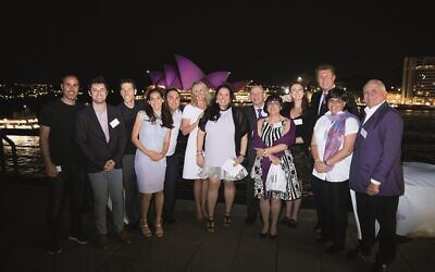 The #PurpleOurWorld team, ambassador Tracey Spicer and newsreader Peter Overton with the sails of the Sydney Opera House lit purple for WPCD.