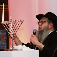 Cantor Sholom Engel from Chabad House Glen Eira lights the first candle of Chanukah. Photo: Peter Haskin