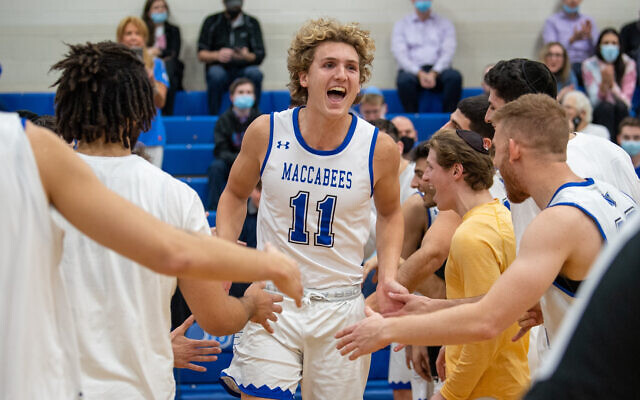 Ryan Turell celebrates another win with his Yeshiva University men's basketball teammates. Photo: Yeshiva University