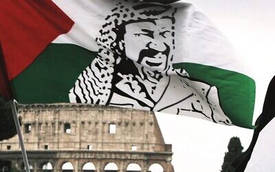 A demonstrator in Rome waves a Palestinian flag portraying Yasser Arafat during a protest in front of the Colosseum. 
Photo: AP/Alessandra Tarantino