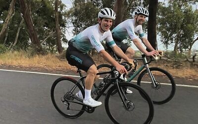 Tim Sackville (left) cycling alongside friend Theo Code.