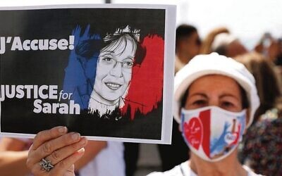 A woman holds up a sign during the day of rallies around the world protesting the French judicial system's handling of the Sarah Halimi case in April 2021. Photo: Jack Guez/AFP/Getty Images