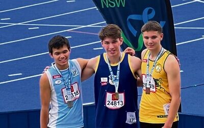 Zac Urbach (centre) after winning gold at the NSW Little Athletics state championships.