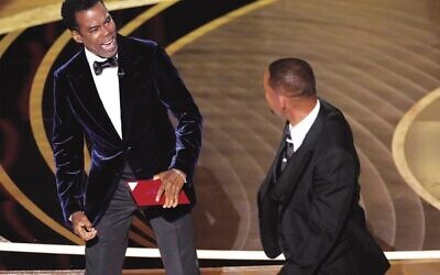 Chris Rock, left, reacts after being hit on stage by Will Smith at the Oscars last month. Photo: AP Photo/Chris Pizzello